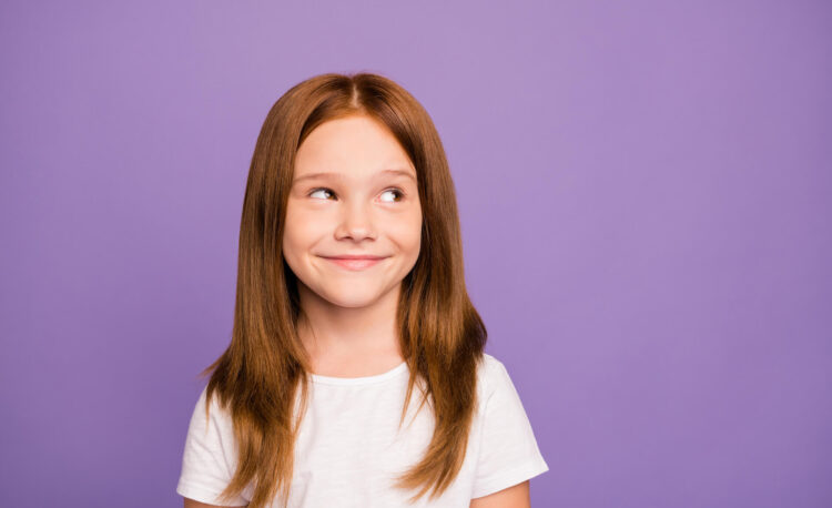 Girl smiling against solid purple background