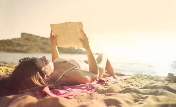 Woman on the beach reading a book