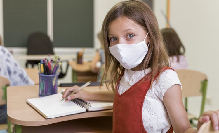 Girl wearing mask in classroom